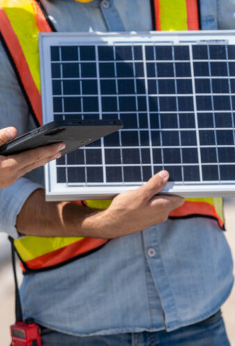 Businessmen and engineers talking and checking quality power solar cell with digital tablet on construction site.
